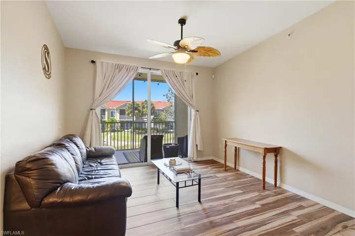 Bright, open living space with modern wood-look tile and abundant natural light.