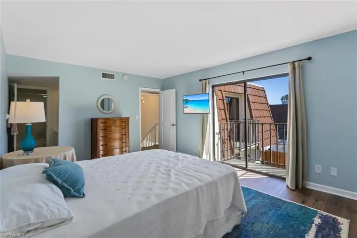 Primary Bedroom featuring wood finished floors and access to exterior