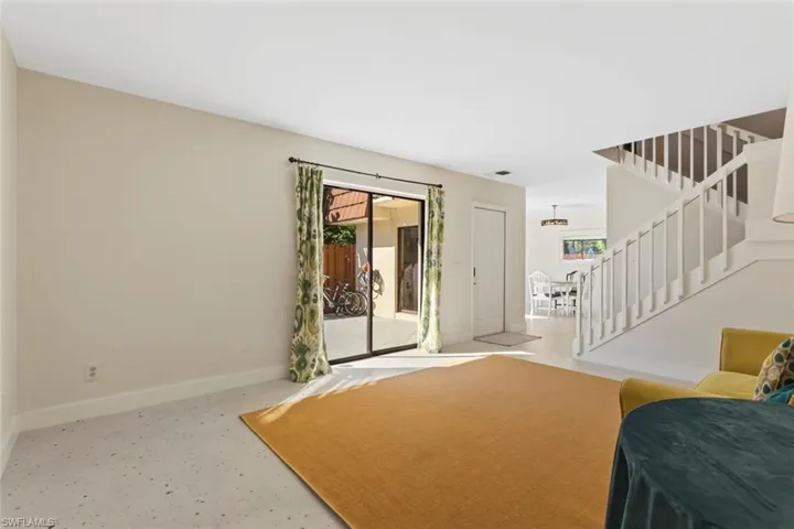 Living area with stairway and baseboards