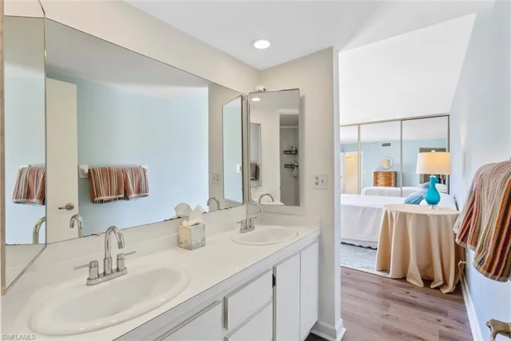 Primary bathroom with ensuite bathroom, double vanity, and light wood finished floors