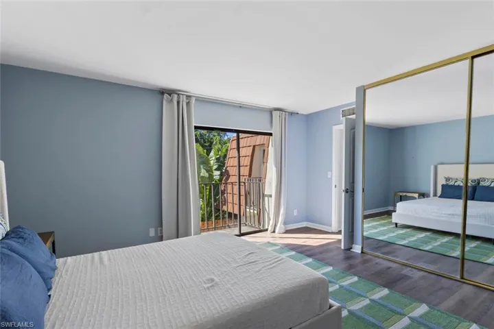 Bedroom with wood finished floors, a closet, and access to exterior