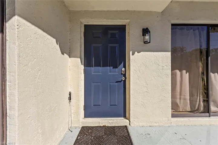 Doorway to property featuring stucco siding