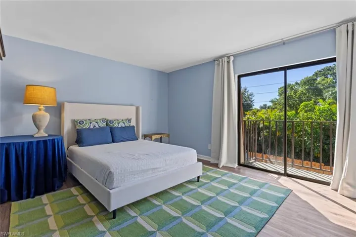 Bedroom featuring access to exterior and wood finished floors