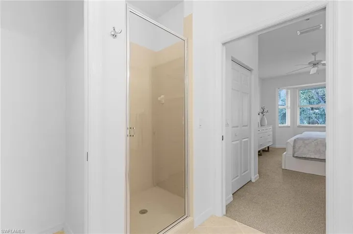 Primary en-suite bathroom featuring tile patterned floors, shower with separate bathtub, and double vanities.