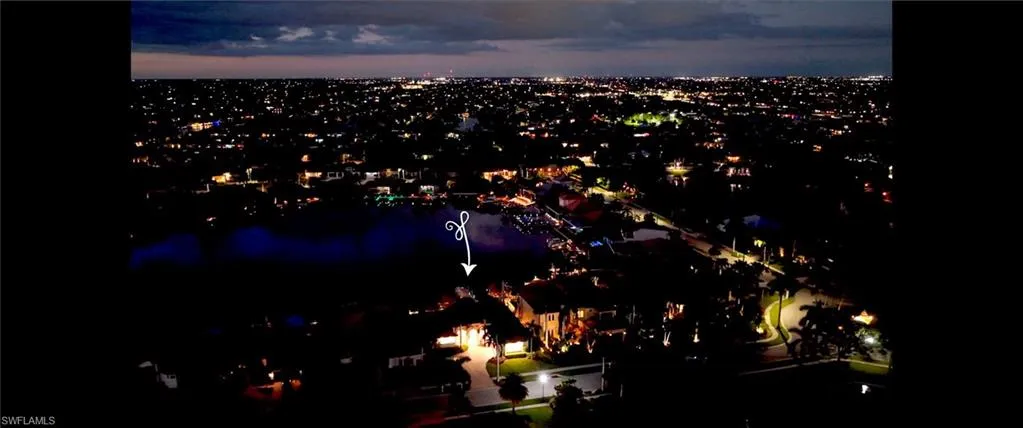 Evening photo of home, lake, Harbour Circle Community Fountain, and the City of Cape Coral