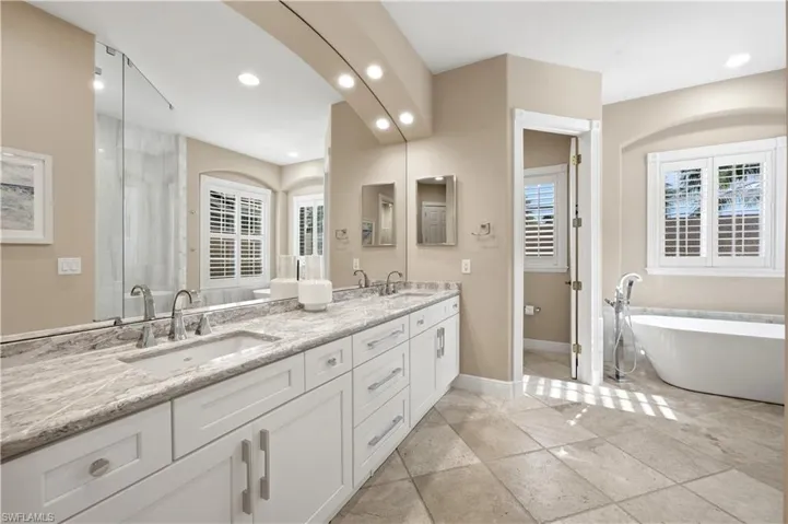 Remodeled Bathroom with split sinks, soaking tub, and Travertine flooring.
