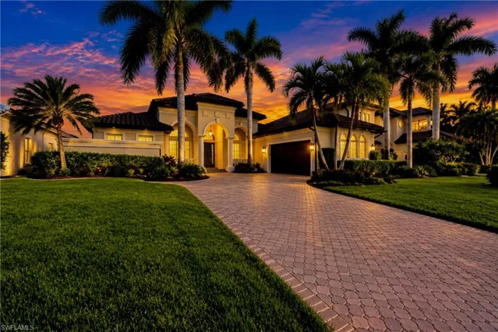 Virtual Twilight photo of Sailboat Gulf Access Home with paver driveway and side-entry garage. Located inside the gated Cape Harbour Yachting Community with underground power, curbs, sidewalks, and Royal Palm lined streets.