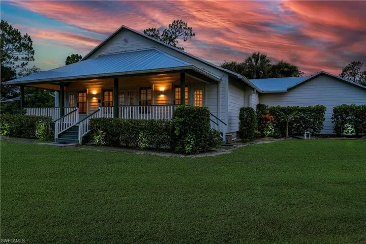 View of front of home featuring a lawn, a metal roof, and a porch