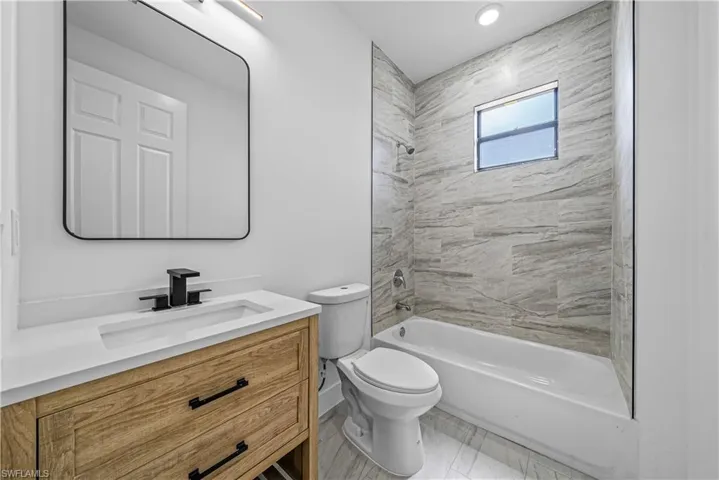 Full bath featuring vanity and washtub / shower combination