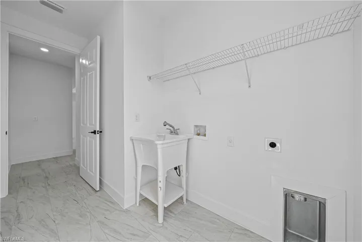 Laundry area featuring light marble finish floors, hookup for a washing machine, and electric dryer hookup
