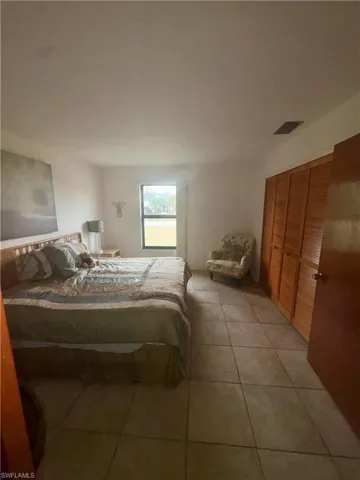 Bedroom featuring light tile patterned floors and a closet