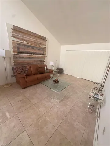 Living area with lofted ceiling and light tile patterned floors