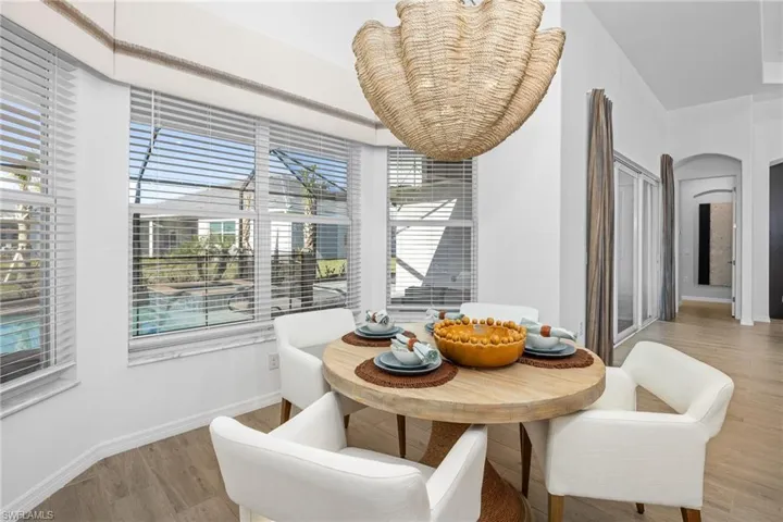 Dining area featuring arched walkways and light wood finished floors