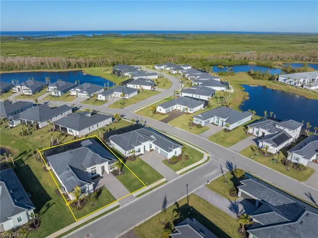 Aerial perspective of suburban area with a large body of water and property parcel outlined