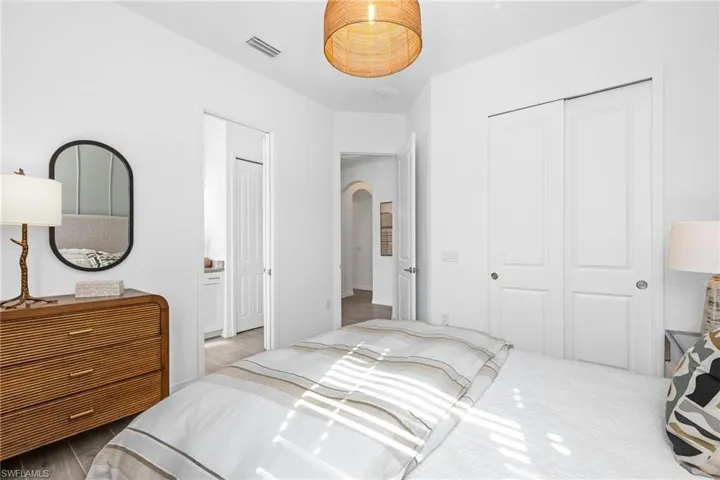 Bedroom featuring arched walkways, a closet, and connected bathroom