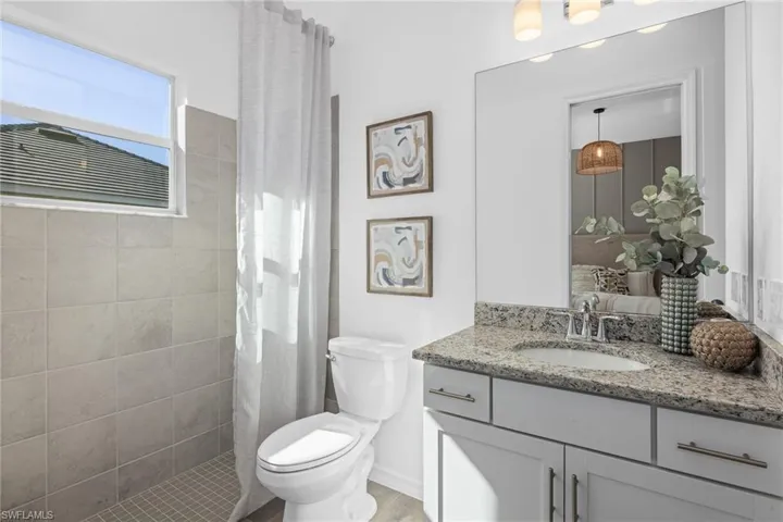Bathroom with vanity and tiled shower