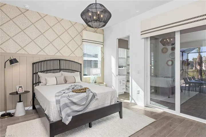 Bedroom with wood tiled floors, multiple windows, and access to outside