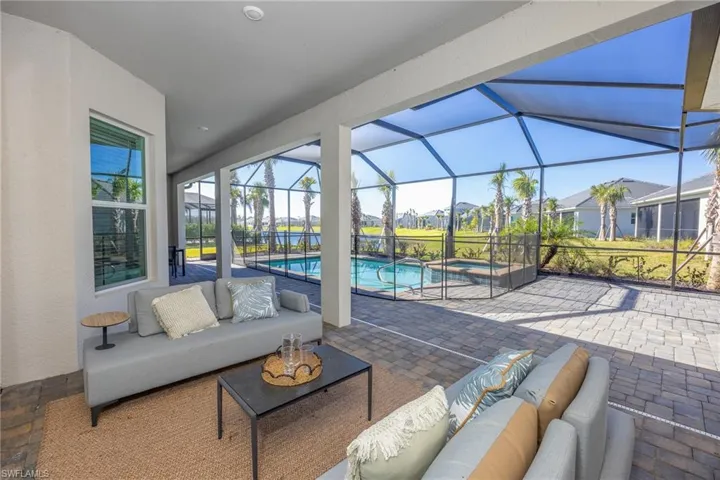 View of patio / terrace with an outdoor living space, a pool with connected hot tub, and glass enclosure