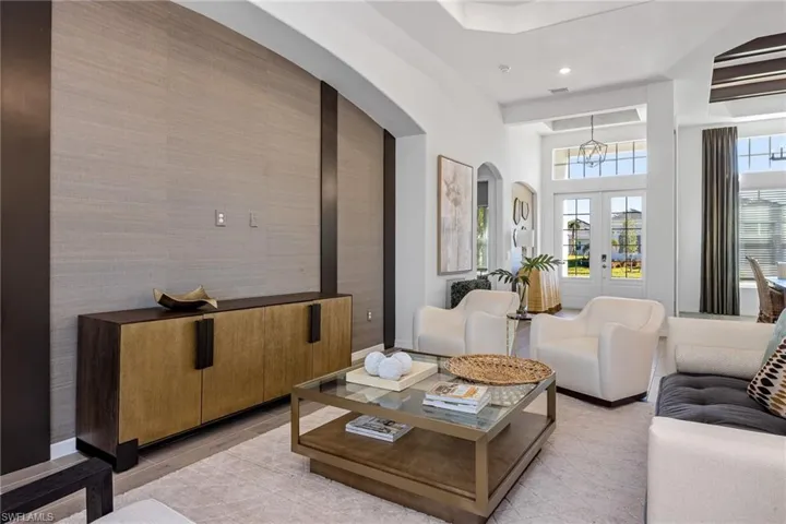 Living area featuring arched walkways, a chandelier, french doors, recessed lighting, and light wood finished floors