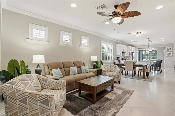 Living room with crown molding, recessed lighting, a ceiling fan, and light tile patterned floors