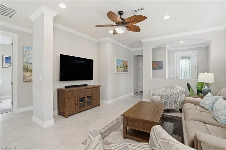 Living area with crown molding, recessed lighting, and a ceiling fan