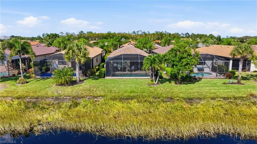 Aerial view of residential area featuring a large body of water and a pool