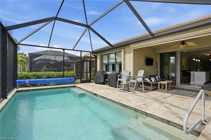 Outdoor pool featuring a sunroom, glass enclosure, a patio area, and ceiling fan