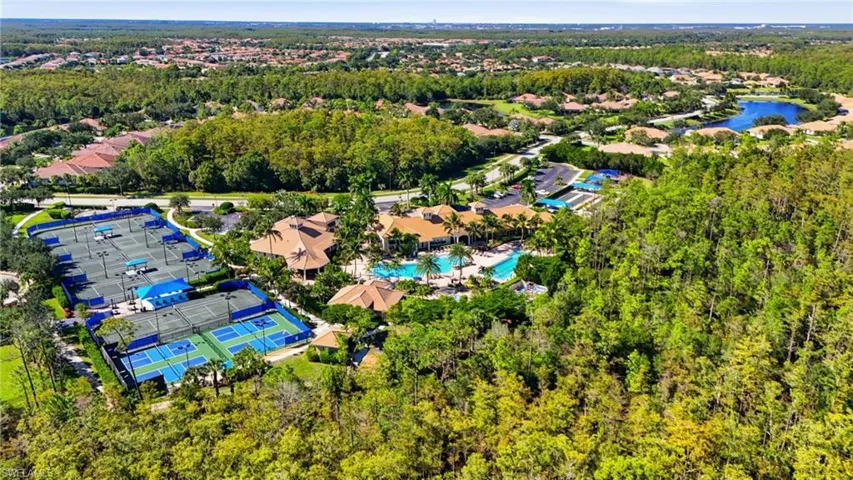 Aerial perspective of suburban area featuring a pool area and a nearby body of water