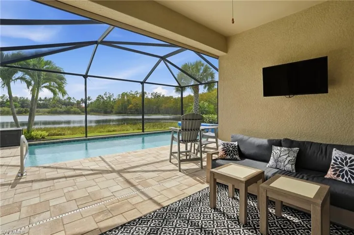 Swimming pool featuring a sunroom, a patio area, glass enclosure, and an outdoor hangout area