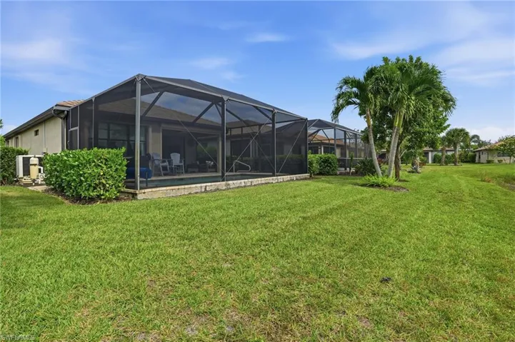 View of green lawn with a lanai, a sunroom, and an outdoor pool