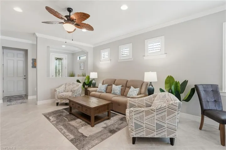 Living area with crown molding, recessed lighting, ceiling fan, and arched walkways