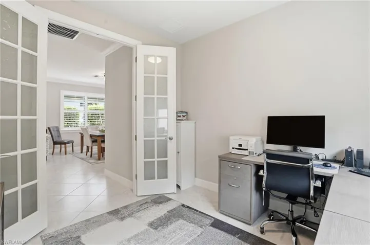 Office with french doors and light tile patterned floors