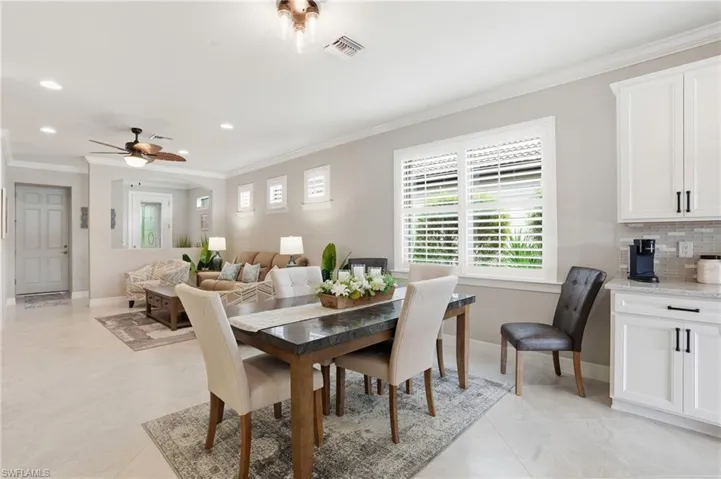 Dining area with ornamental molding, recessed lighting, arched walkways, light tile patterned floors, and a ceiling fan