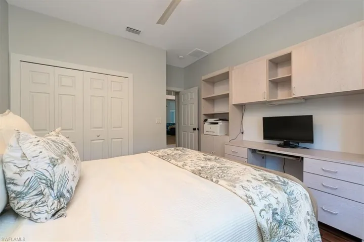 Bedroom with built in desk, a ceiling fan, and a closet