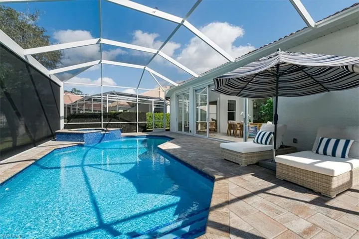 Relaxing pool / spa featuring a patio area, a sunroom, and glass enclosure