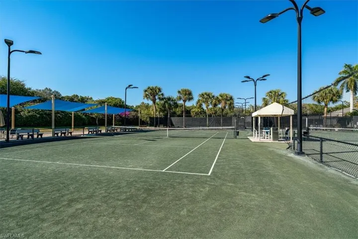 View of tennis court with a gazebo and a patio area