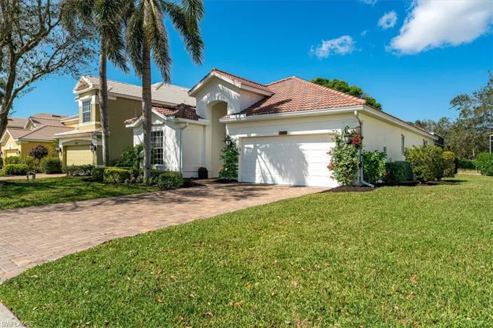 Mediterranean / spanish home featuring stucco siding, driveway, an attached garage, and a front yard