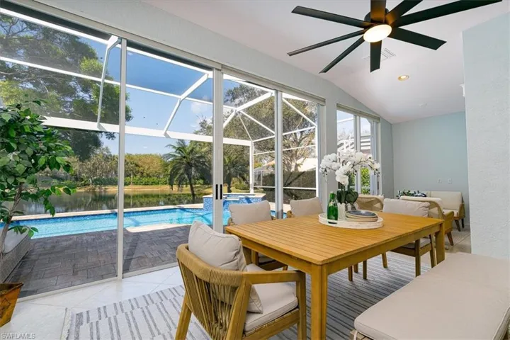 Sunroom / solarium with outdoor dining area, ceiling fan, a water view, and vaulted ceiling