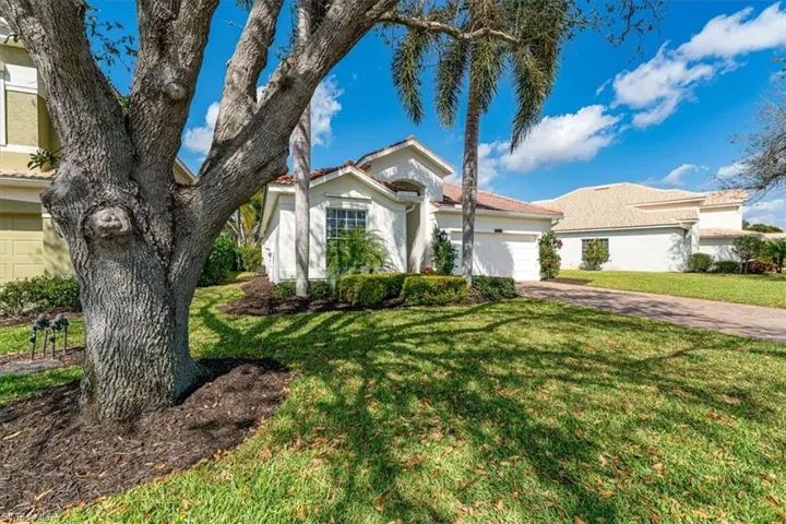 Mediterranean / spanish house featuring a garage, a front yard, driveway, and stucco siding