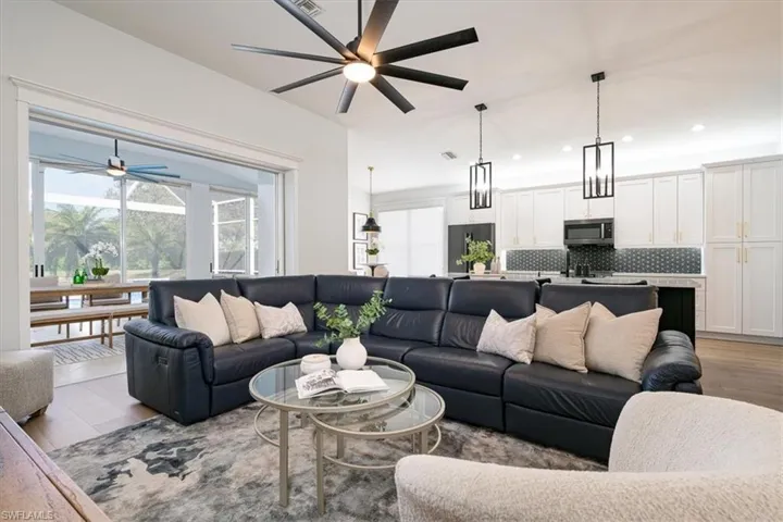 Living area with a ceiling fan, light wood finished floors, and recessed lighting