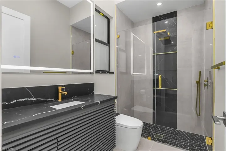 Full bath with a stall shower, vanity, and light tile patterned flooring