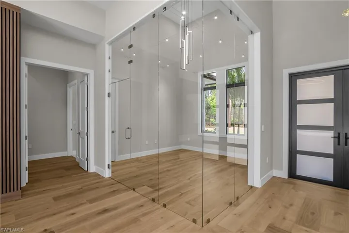 Foyer entrance with light wood finished floors and a high ceiling