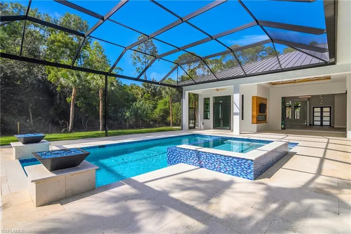 Integrated pool / spa featuring french doors, a patio, a sunroom, and a lanai