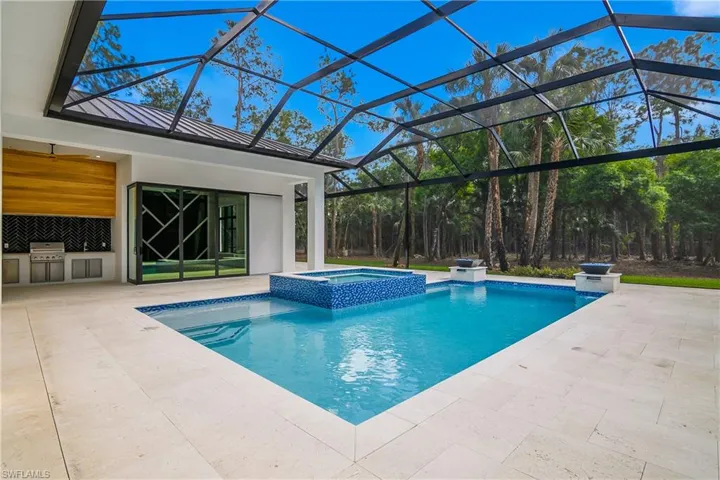 Relaxing pool / spa with area for grilling, a patio area, a sunroom, and a lanai