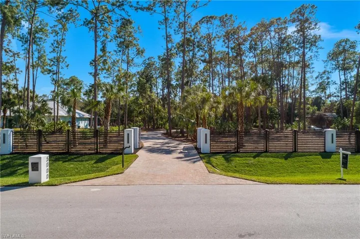 View of property featuring a fenced front yard and a gate