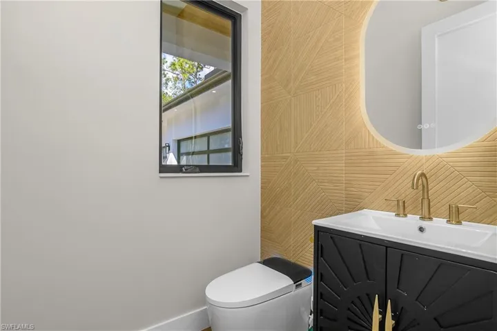 Half bath featuring vanity and tile walls