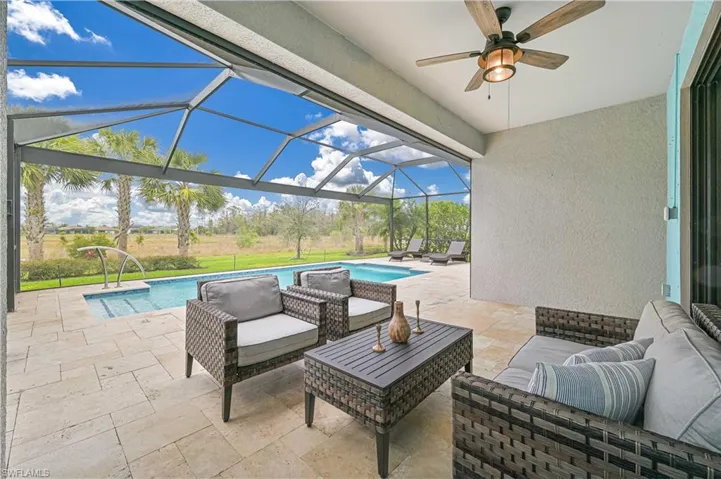 View of patio featuring an outdoor pool, glass enclosure, an outdoor hangout area, and ceiling fan