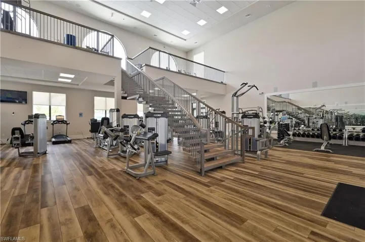 Gym featuring visible vents, a high ceiling, and wood finished floors
