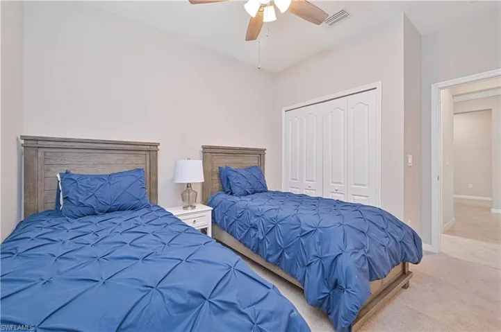 Bedroom featuring visible vents, baseboards, carpet flooring, a closet, and a ceiling fan