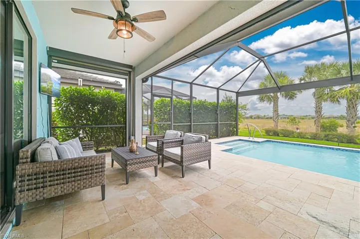 Outdoor pool featuring a ceiling fan, glass enclosure, a patio area, and outdoor lounge area